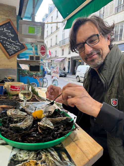 Huron's John Kosta on a break between tours, enjoying some oysters at a street-side fresh seafood market in Paris in 2024